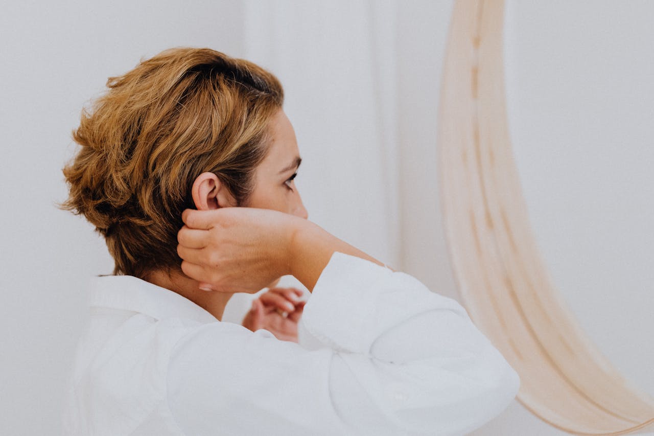 Woman in White Long Sleeve Shirt Facing the Mirror