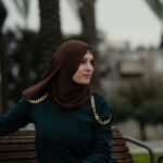 a woman in a hijab sitting on a bench